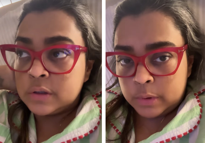 preta gil com óculos de armação grossa e pijama em uma cama de hospital