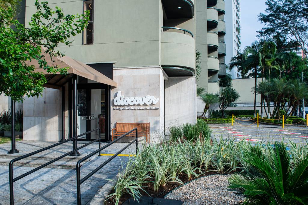 Drogaria Discover. Fachada cinza com letreiro branco