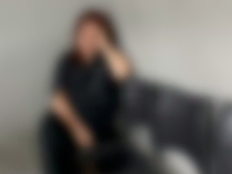 a imagem embaçada de uma mulher branca, de cabelos ruivos, sentada com a mão "segurando" a cabeça