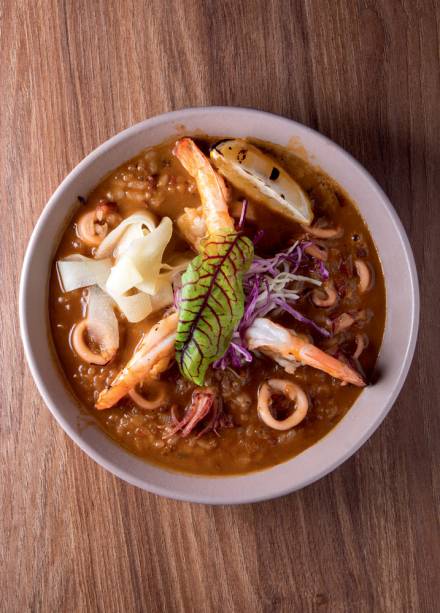 Jollof: arroz caldoso ao leite de coco e com camarão e lula coberto de saladinha de repolho