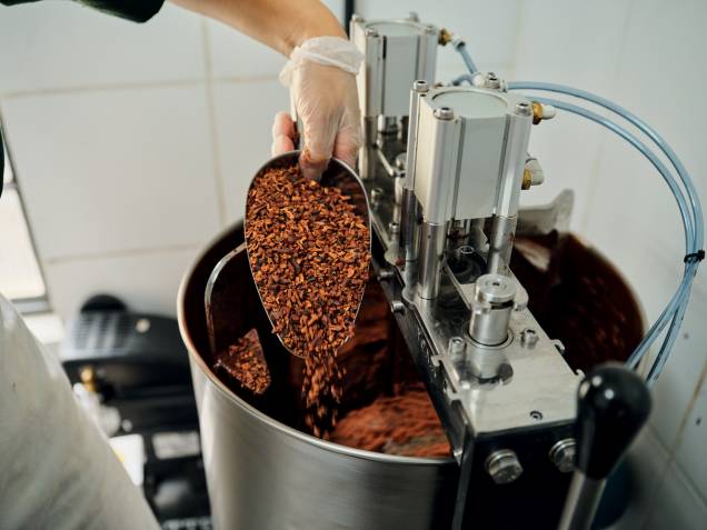 Etapa 1: colocação dos nibs de cacau no moinho de pedras Etapa 1: colocação dos nibs de cacau no moinho de pedras