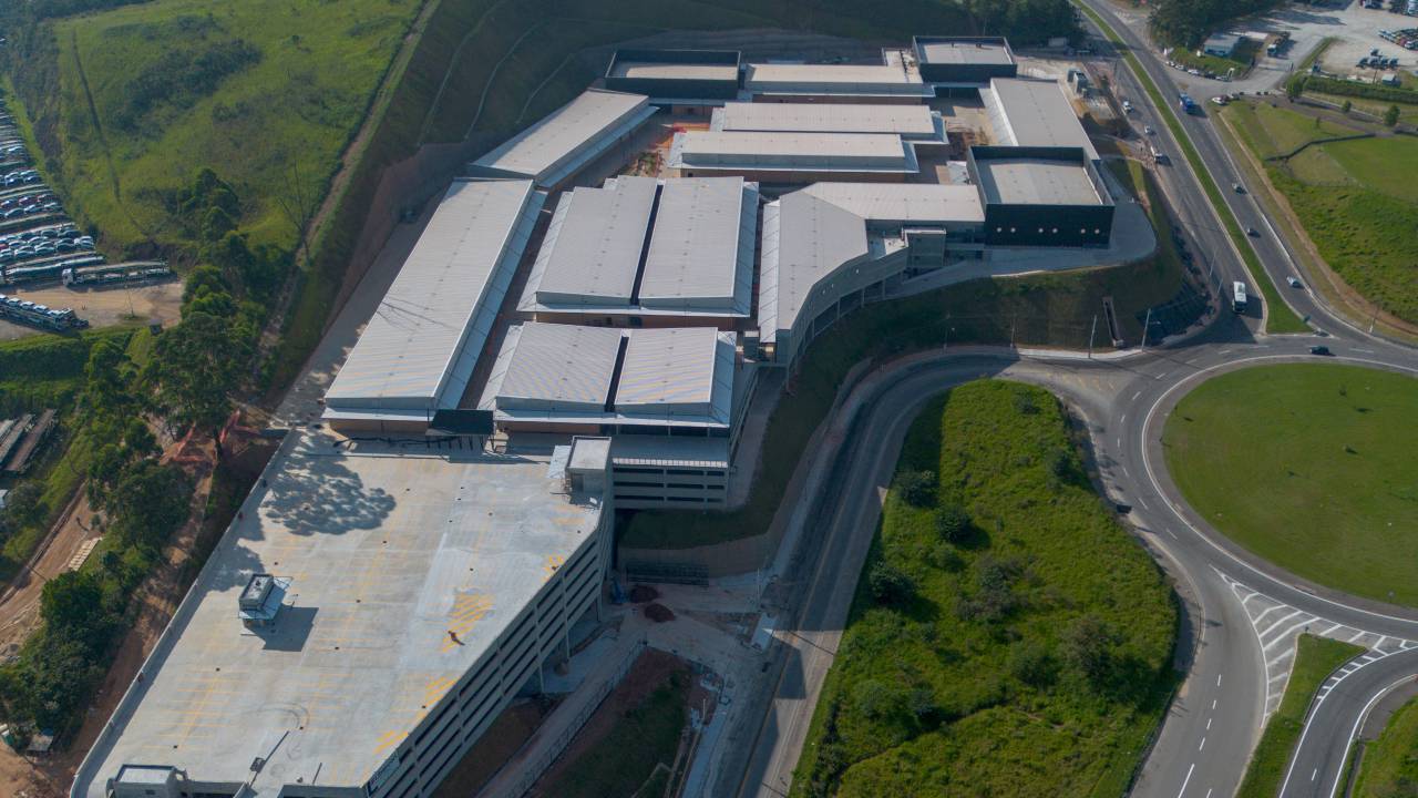 Vista aérea de shopping com rodovias e área verde ao redor