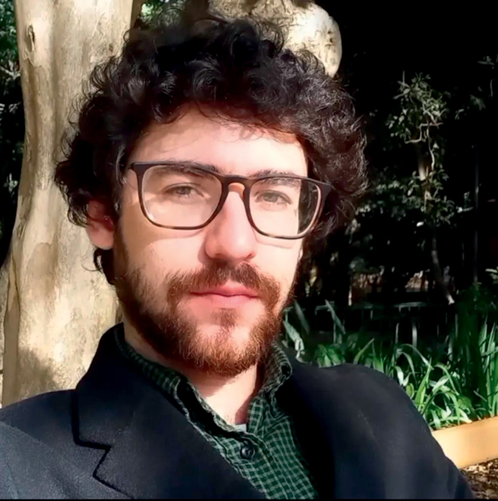Tálisson Melo, curador e professor USP-Crédito Arquivo Pessoal.jpg Homem branco de barba e cabelos escuros encaracolados usa óculos e encara a câmera. Ao fundo, árvore e plantas verdes
