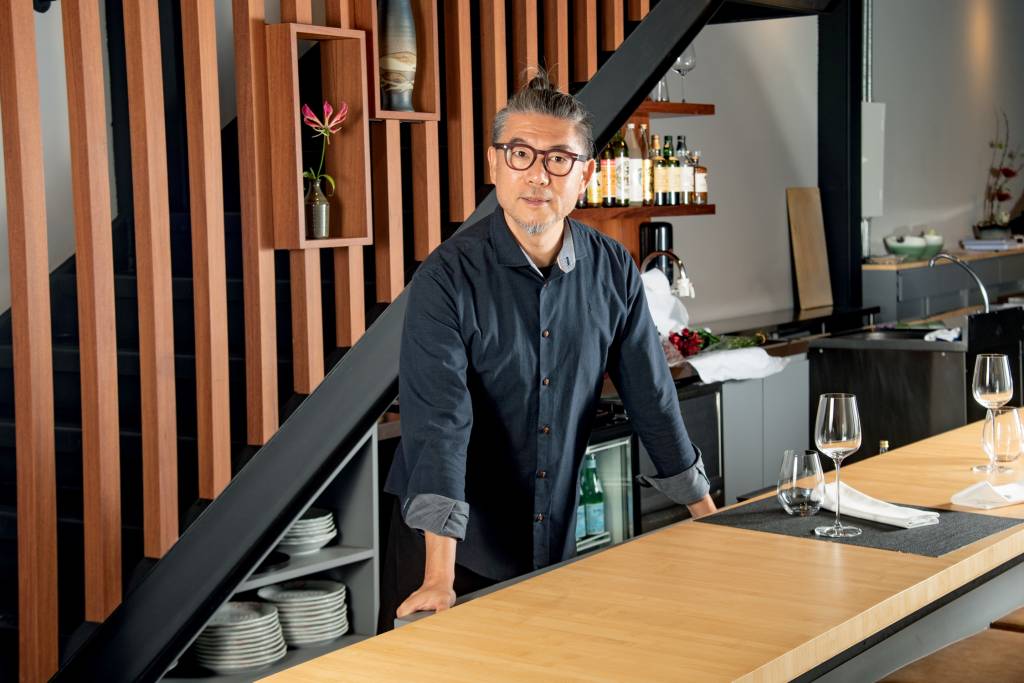 Dia dos Namorados – Murakami Homem asiático atrás de balcão de madeira de restaurante.