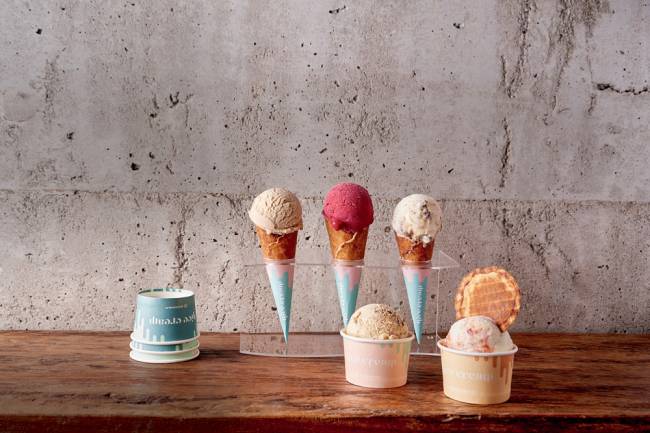 Nice Cream Casquinhas de sorvete com sorvetes coloridos e copinhos em cima de uma mesa