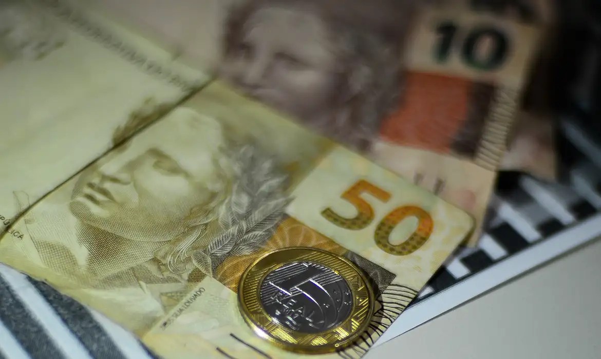 Notas de real e moeda de um real