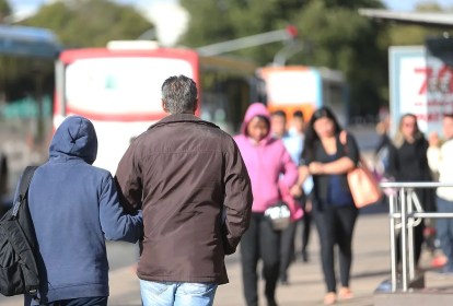 Duas pessoas andando com blusas de frio