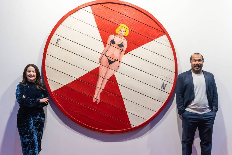 O galerista Antonio Almeida e a esposa Michele Uchoas com a obra de Emmanuel Nassar