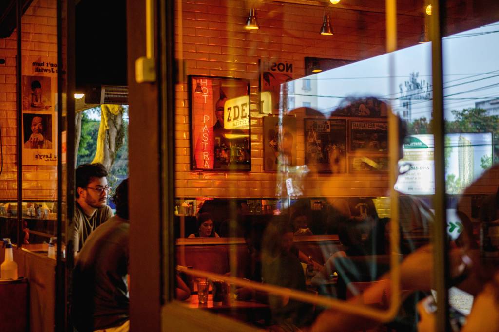 0133 Z Deli Bairro de Pinheiros.jpg Vidraça de hamburgueria com clientes no interior
