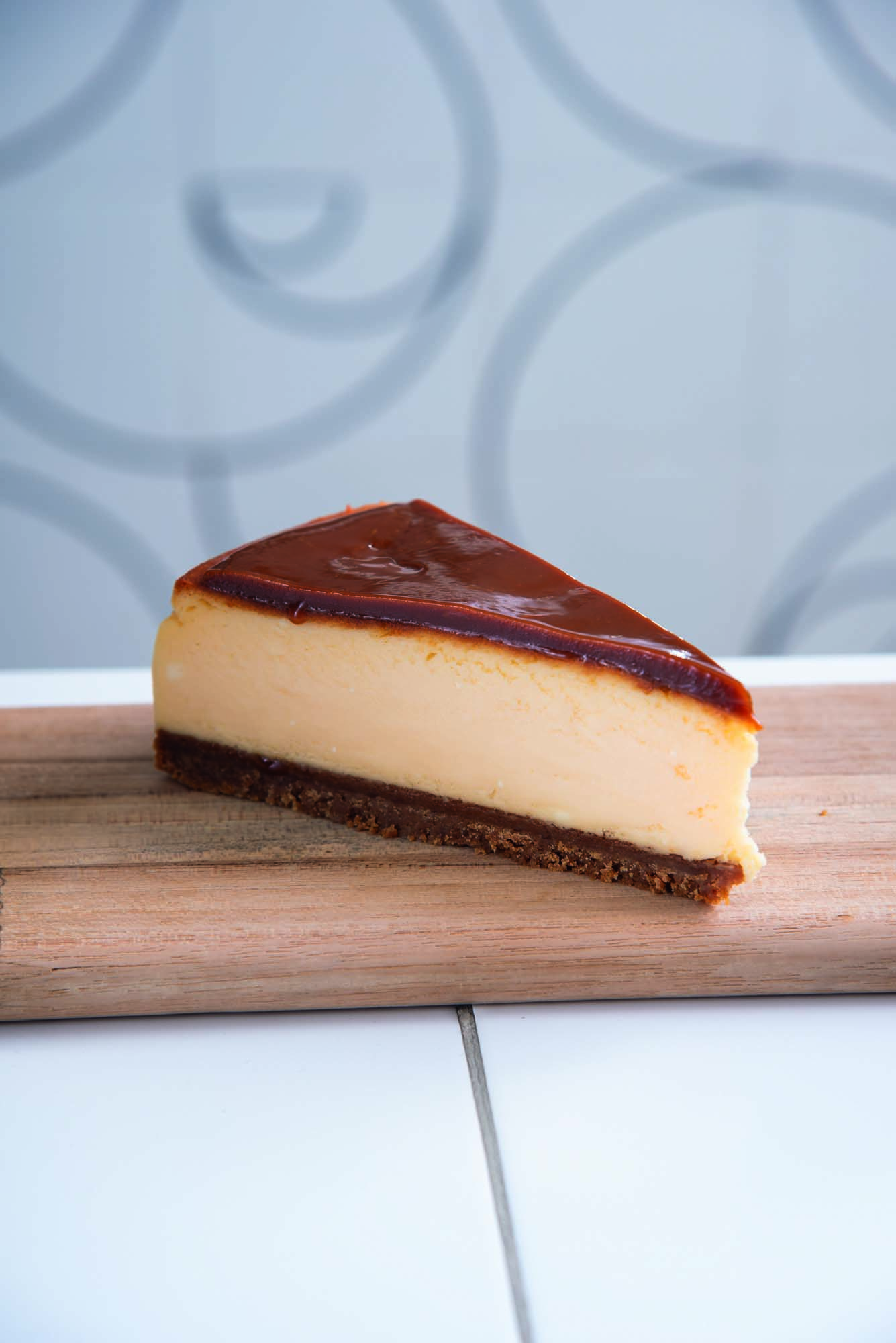 Peda&ccedil;o de cheesecake em cima de recipiente de madeira