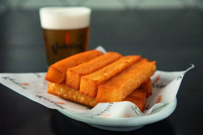Polenta frita – Galetim Porção de polenta frita com cerveja atrás