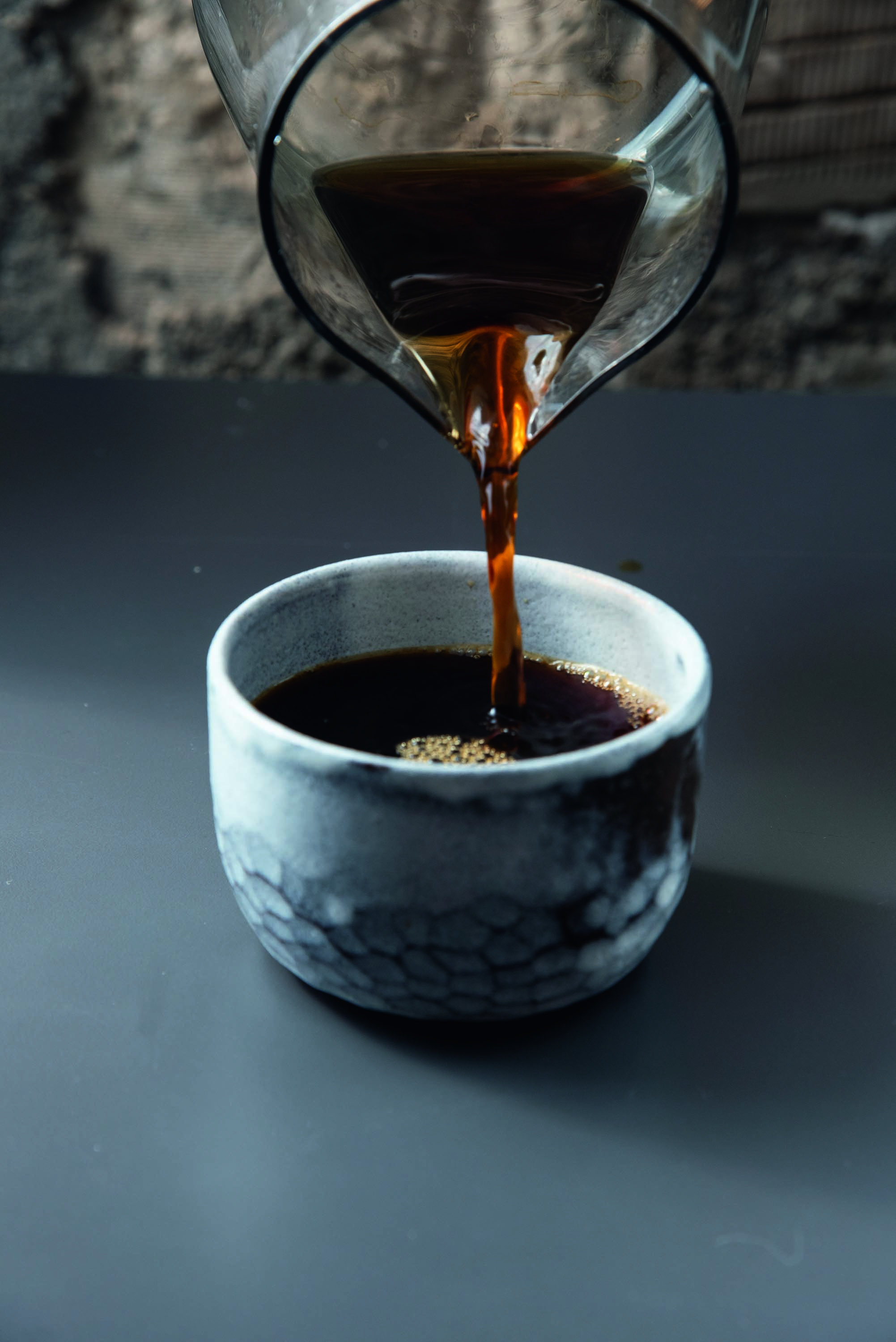 Caf&eacute; coado sendo colocado em x&iacute;cara redonda