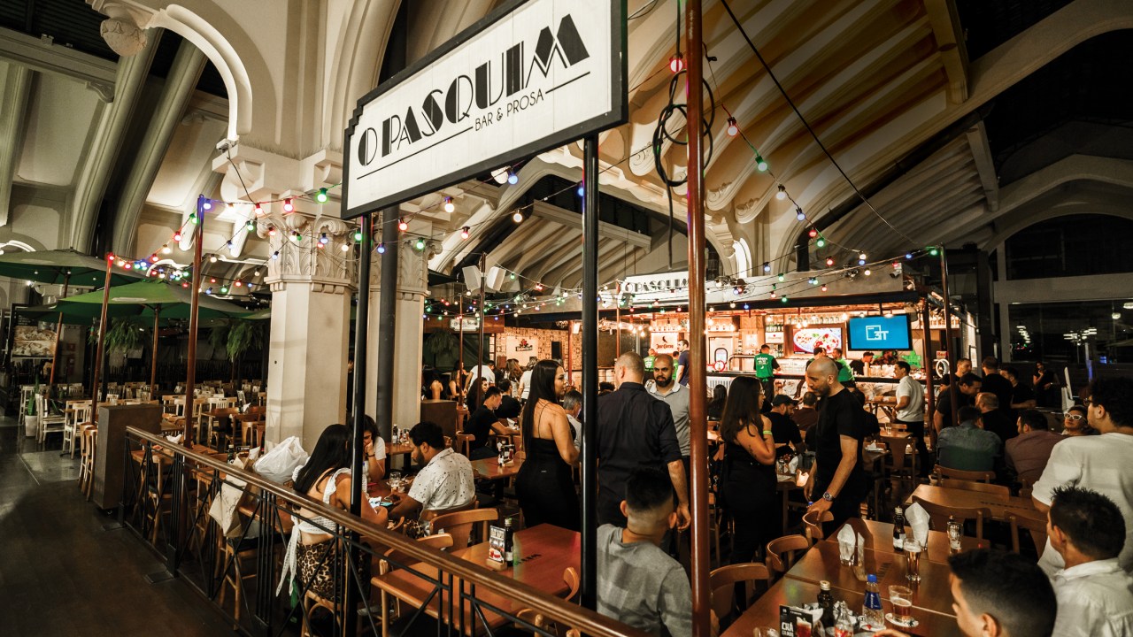 Frente do bar no mercadão com muitas pessoas nas mesas