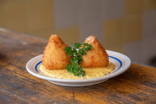 Prato branco com duas coxinhas.