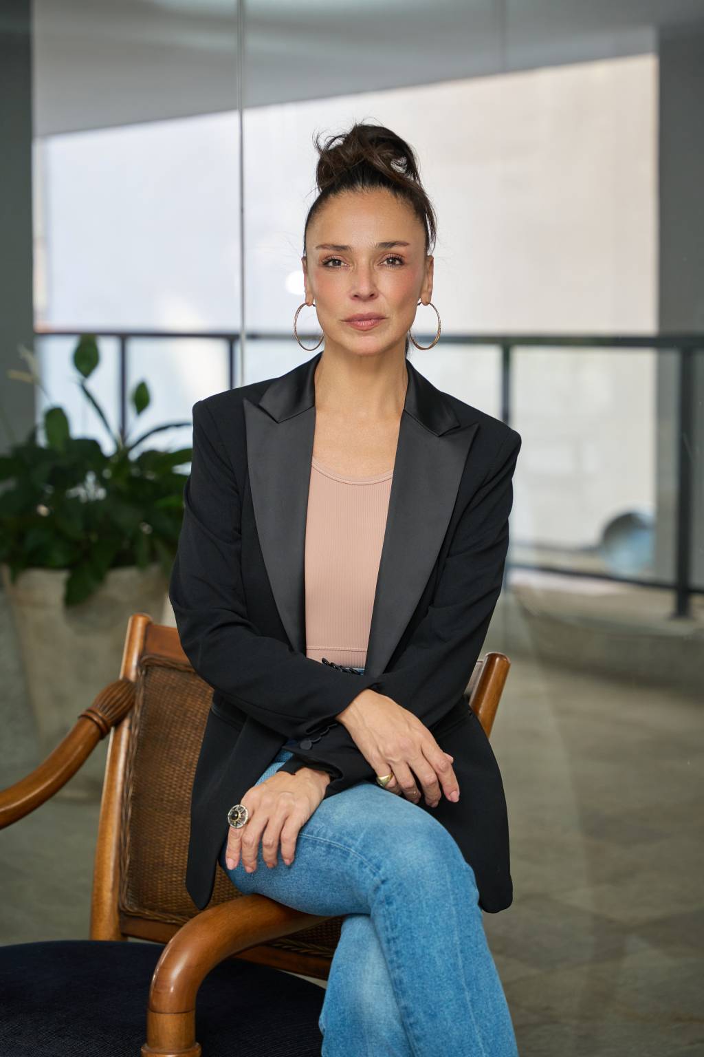 Fernanda Ralston Crédito Iago Alencar-Divulgação (2) Mulher sentada com blazer preto, jeans, de pernas cruzadas, com rabo de cavalo