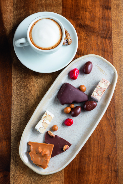 degustação _ Hagi Torrones e Chocolates Vários chocolates e doces e café ao lado