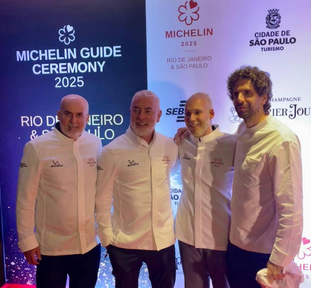 Michelin SP Na frente de um painel de marcas, estão quatro homens, chefs de cozinha: Geovane Carneiro e Alex Atalta (D.O.M.), Luiz Filipe Souza (Evvai) e Ivan Ralston (Tuju)