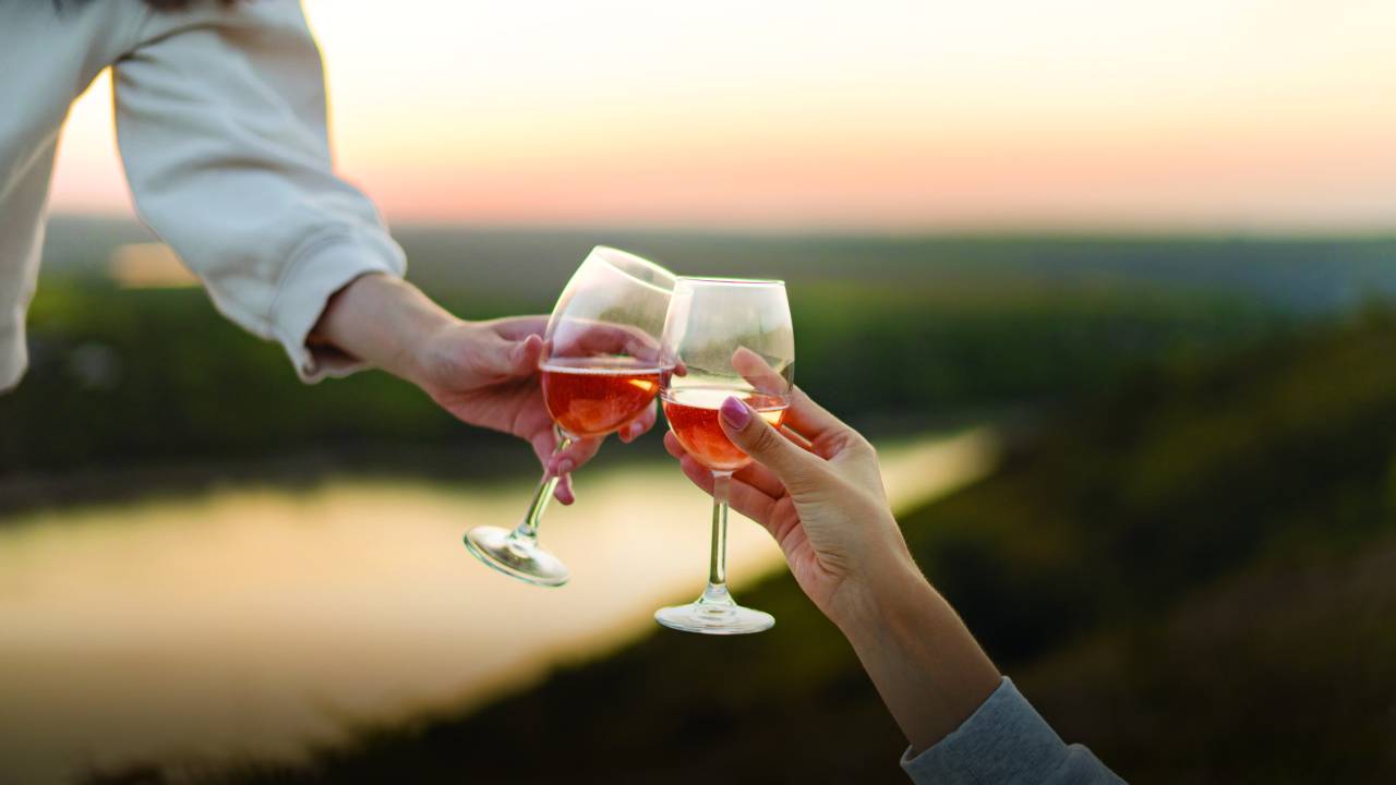 Duas taças brindando com vinho rosé