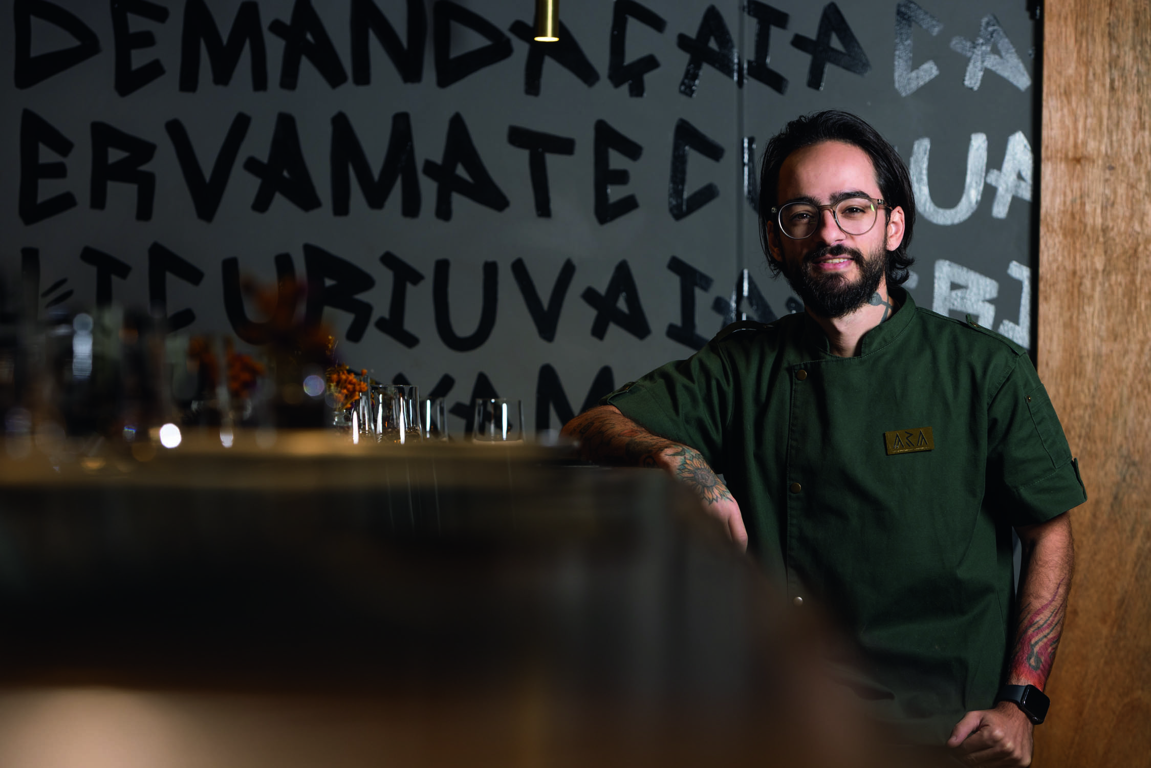 Homem sorrindo encostado em balc&atilde;o