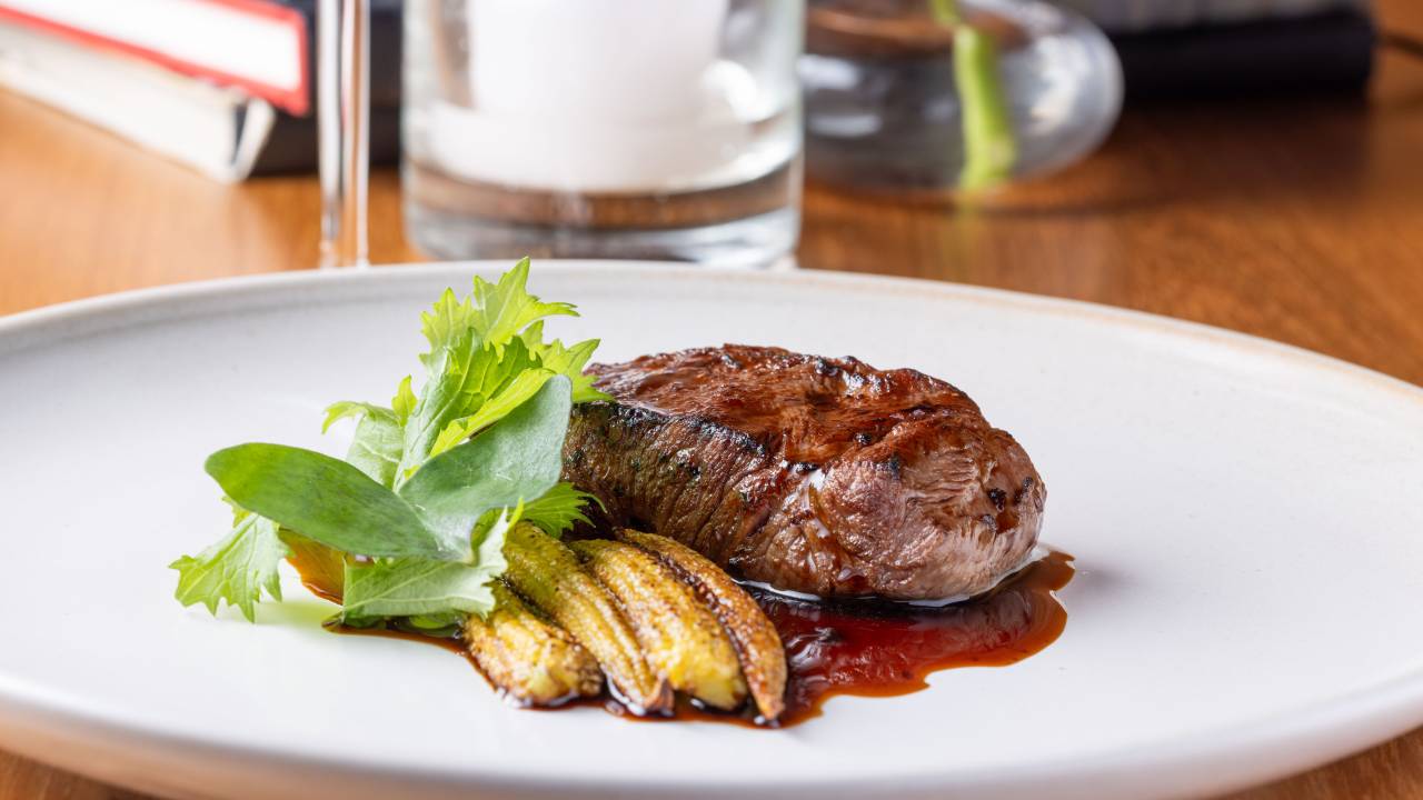 Carne e milho no prato branco