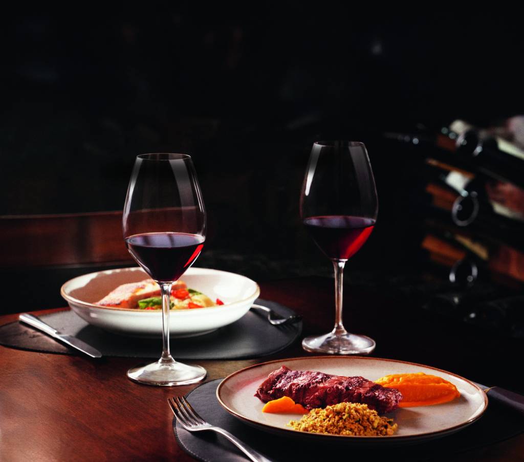POBRE JUAN – Crédito FREDERICO FILICO SOUZA DIVULGAÇÃO_exp.jpg Pratos com carnes e taças de vinho ao lado