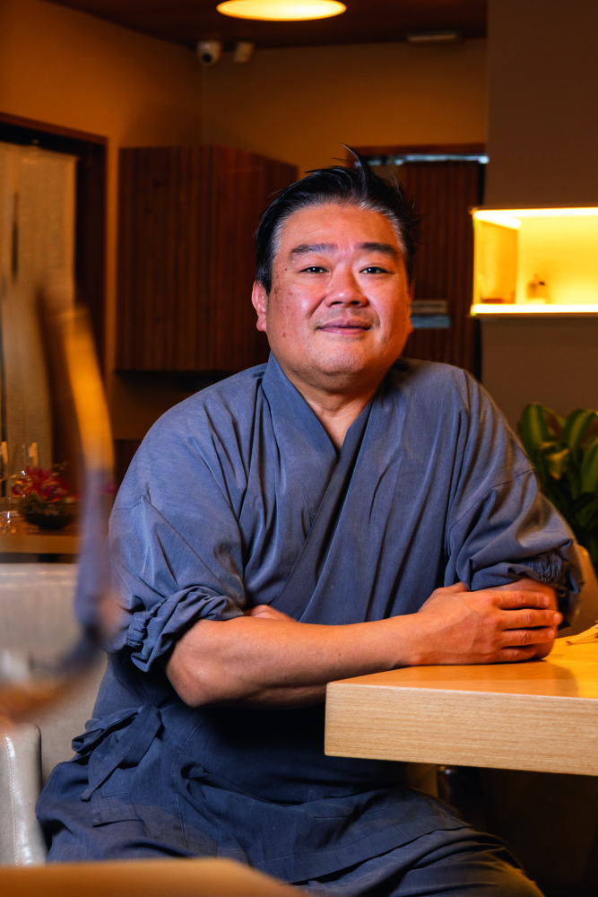 Homem sentado em cadeira e sorrindo