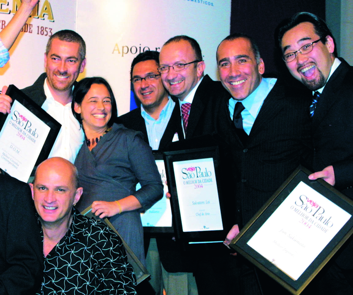 Mulher entre v&aacute;rios homens sorrindo e com placas