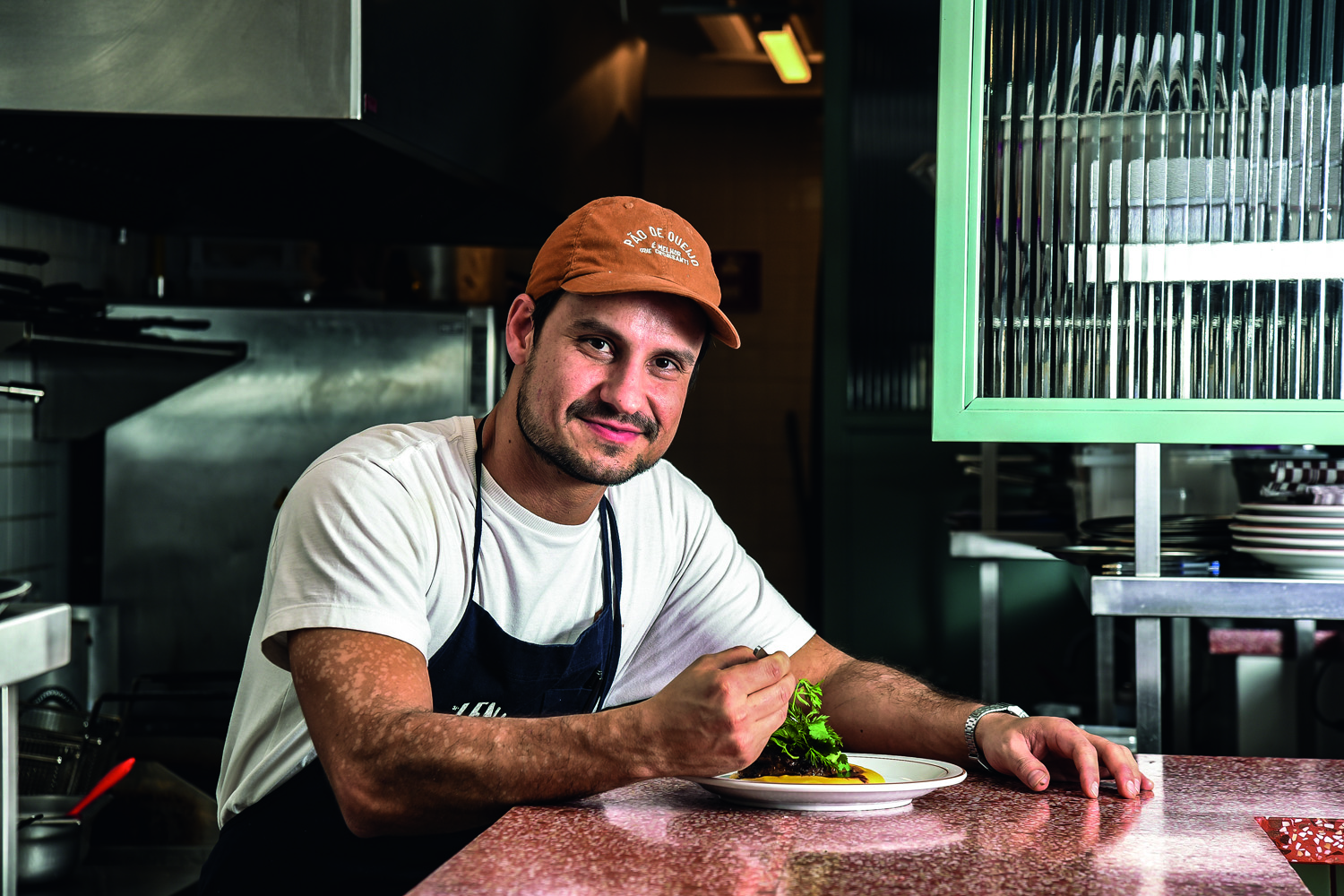 Homem sorrindo e pegando uma comida no prato