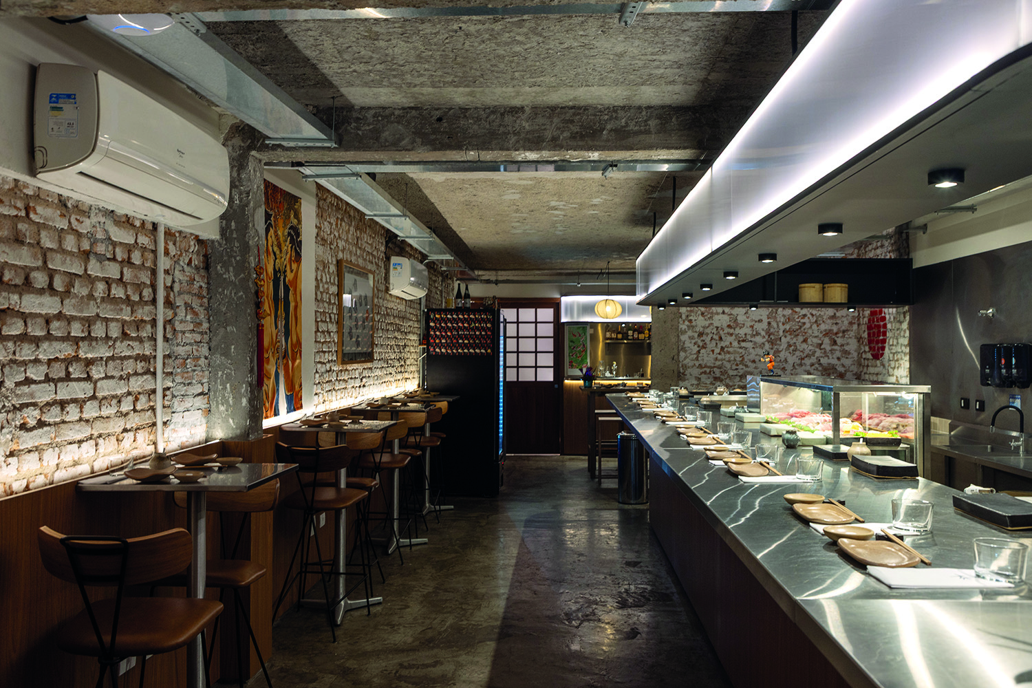 Espa&ccedil;o aberto com balc&atilde;o e mesas ao lado