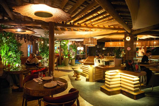 Pessoas sentadas em mesas em salões pequenos