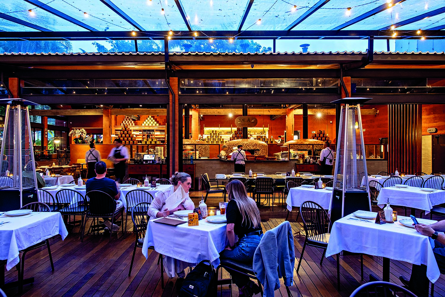 sal&atilde;o da pizzaria com mesas e cadeiras