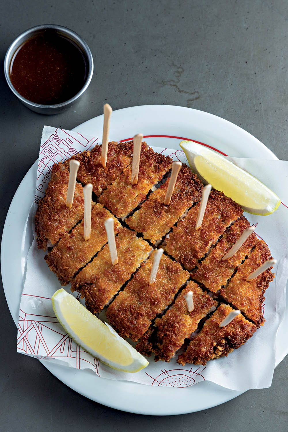 milanesa em prato branco e molho ao lado