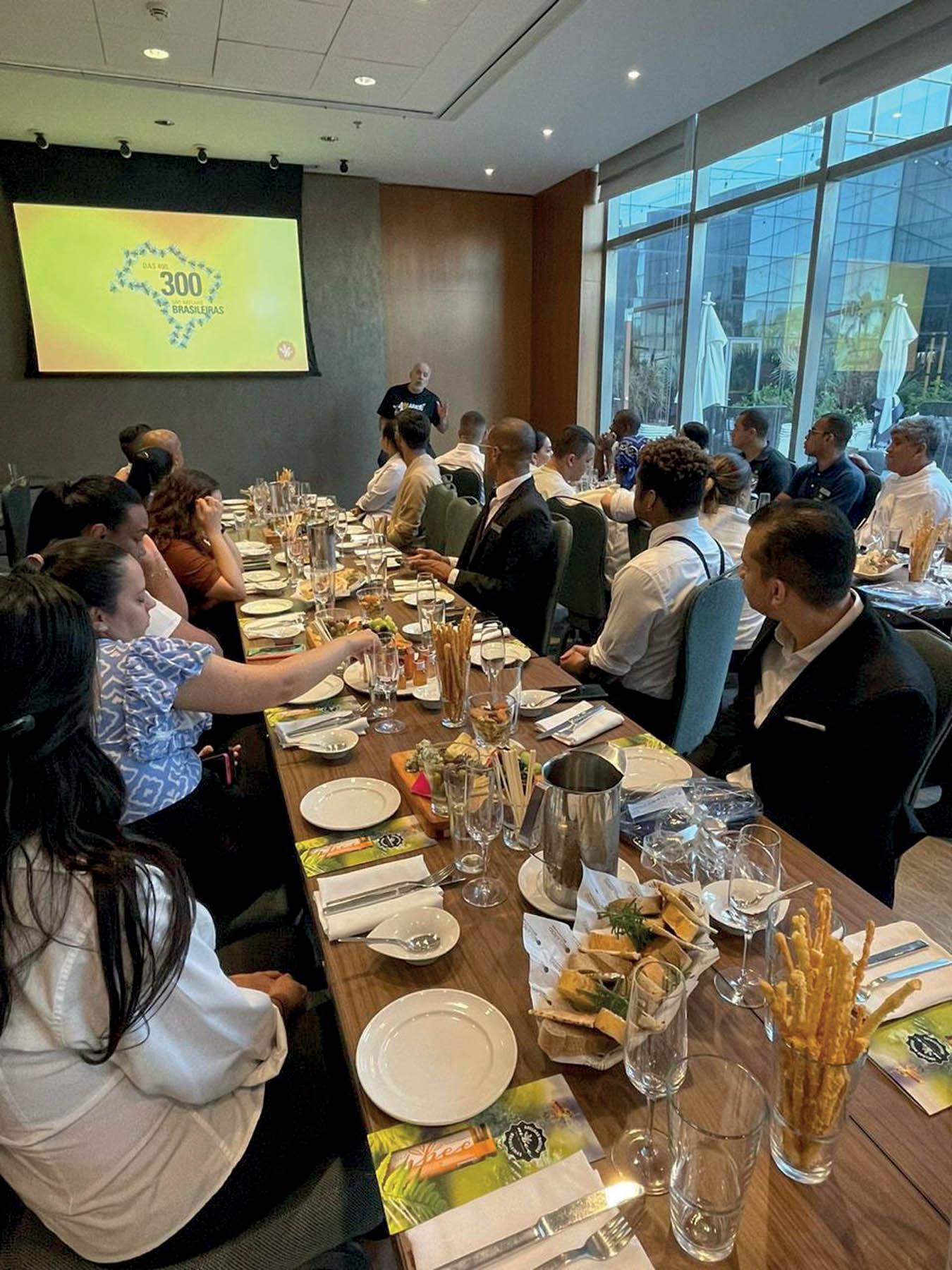 pessoas sentadas em mesas assistindo aula