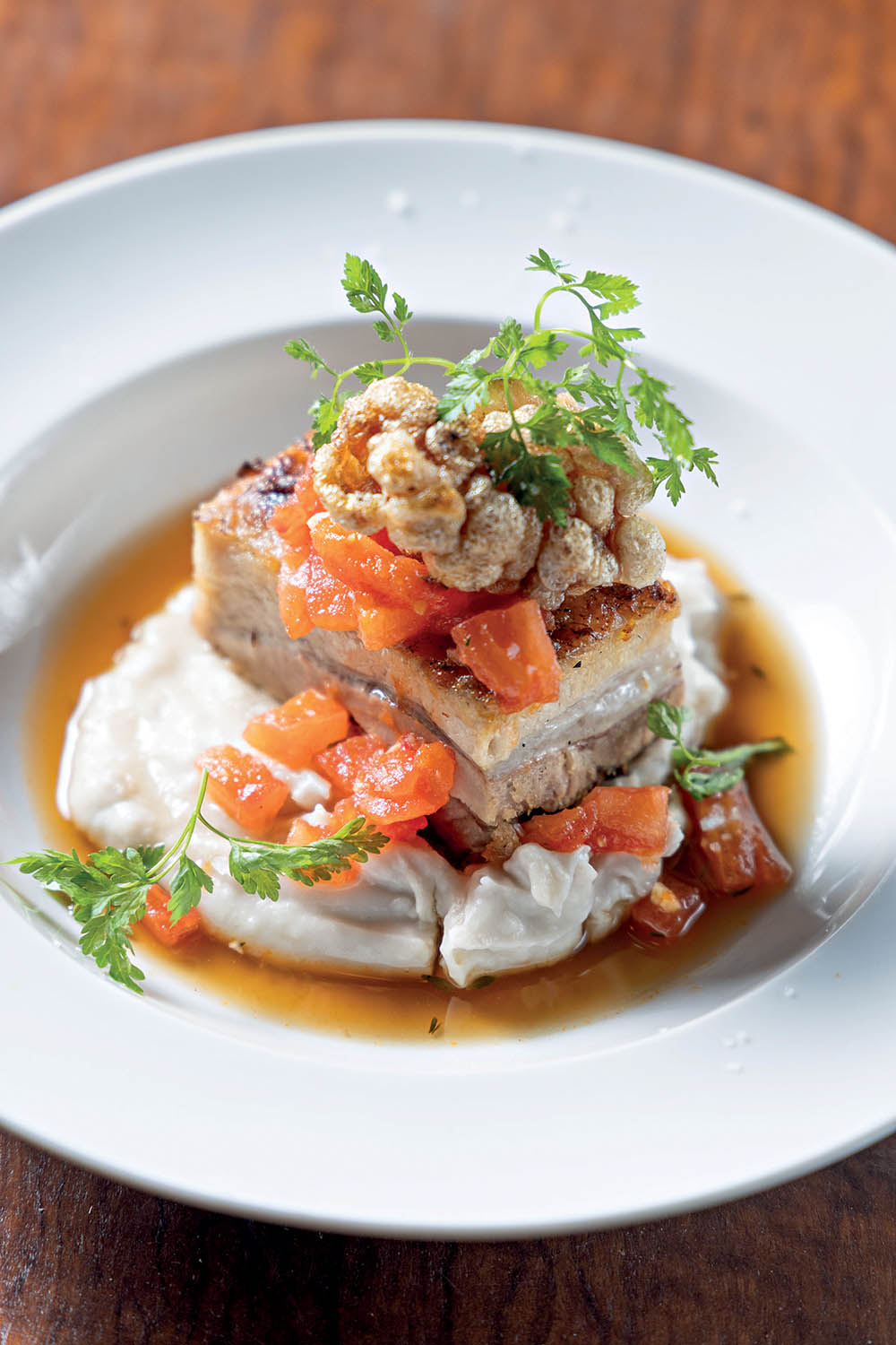 Com cara de prato principal, a barriga de porto &eacute; servida sobre creme de inhame defumado