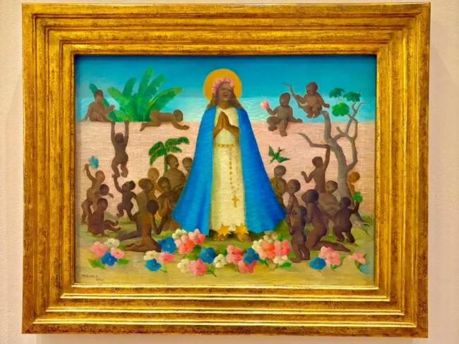 Pintura de Tarsila do Amaral, A Sagrada Fam&iacute;lia, com uma figura central feminina de pele escura, aur&eacute;ola e manto azul, cercada por crian&ccedil;as negras em um cen&aacute;rio tropical com plantas e flores coloridas