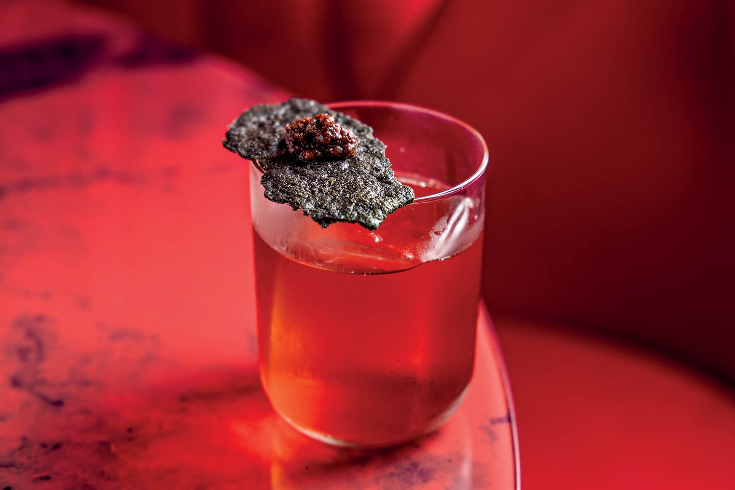 Gravity: bourbon, Campari, vermute tinto, uva-passa e óleo de gergelim